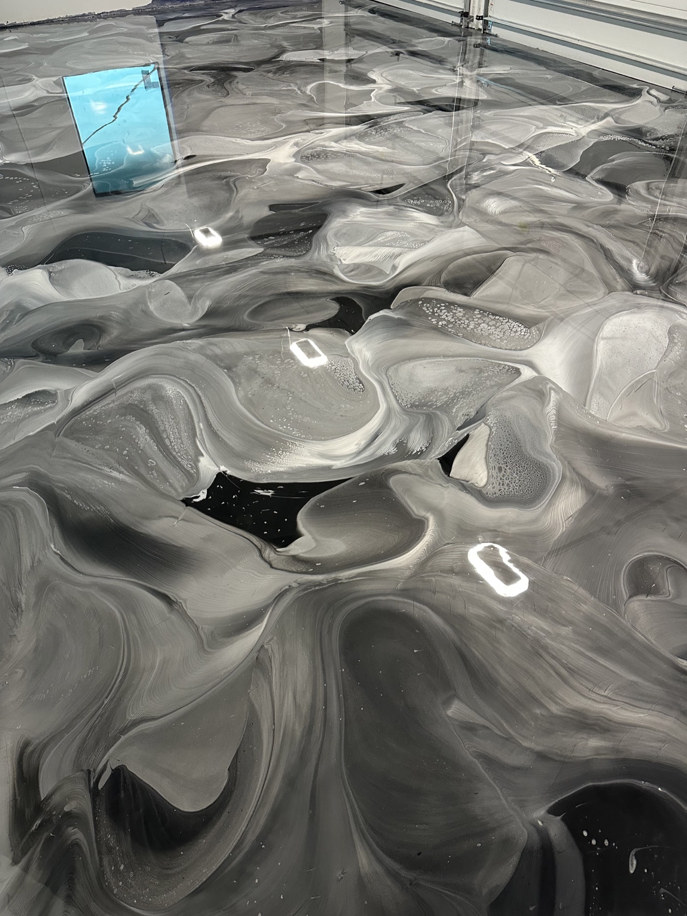 Finished black, silver, and white metallic epoxy floor in a four-car garage
